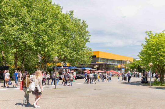 Campusleben mit Studierenden und Mensa im Hintergrund